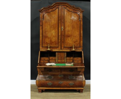 An 18th century Dutch walnut bureau book cabinet, the pair of panel doors above two candle slides and enclosing three adjusta