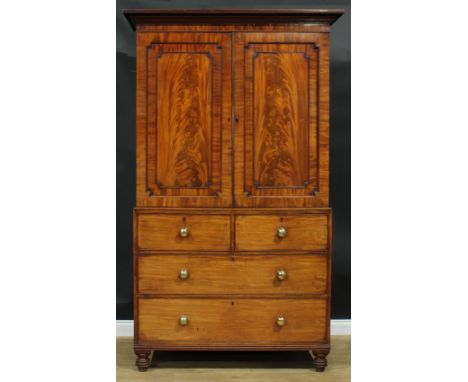 A George IV mahogany hanging press cupboard, formerly a linen press, moulded cornice above a pair of flame veneered panel doo