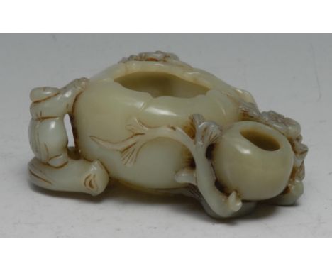 A Chinese celadon jade brush washer, carved with a figure and blossom alongside a peach, 11cm wide 