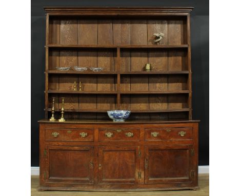 A large George III ash and elm country house dresser, outswept cornice above four plate rack shelves, the projecting base wit