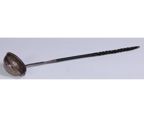 A George III silver coloured metal toddy ladle, the bowl chased with fruiting vine and set with a gilt shilling of 1758, twis
