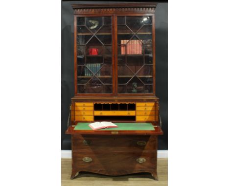 A George III mahogany secretaire bookcase, outswept cornice above a pair of astragal glazed doors enclosing three adjustable 