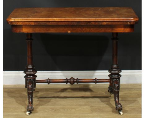 A Victorian walnut and mahogany card table, hinged rounded rectangular top enclosing a baize lined playing surface, turned su