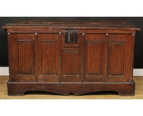 A substantial 17th century oak country house coffer, hinged plank top above a five-panel front carved with linenfolds, divide