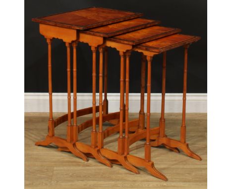 A George III Revival set of rosewood crossbanded satinwood quartetto tables, each with a rectangular top and ring-turned supp