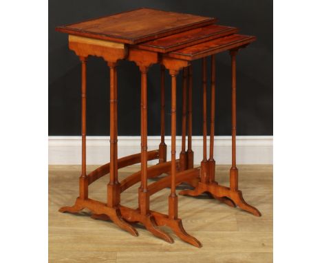 A George III Revival satinwoood nest of three occasional tables, each with a rectangular top and ring-turned supports, the la