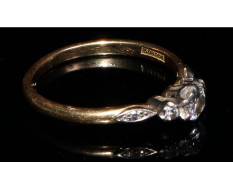 An 18ct gold and platinum three stone diamond ring, diamond chips to navette shaped shoulders, size O/P 