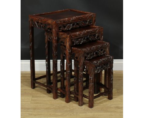 A set of Chinese hardwood quartetto tables, rectangular panel tops, the borders carved with ferocious dragons, the largest 71