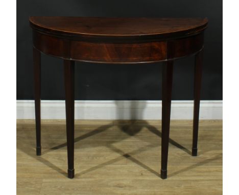 A George III mahogany demilune card table, hinged crossbanded top enclosing a baize lined playing surface, tapered square leg