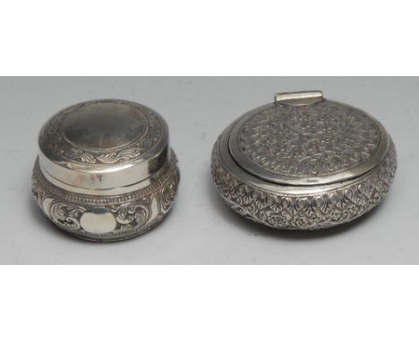 An Indian silver circular snuff box, profusely chased with dense scrolling foliage and flowers, 7cm diam, c.1900; an Idian si