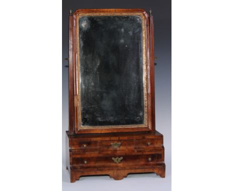 A George II walnut dressing glass, bevelled mirror plate, the concave moulded base with three short and one long drawer, shap