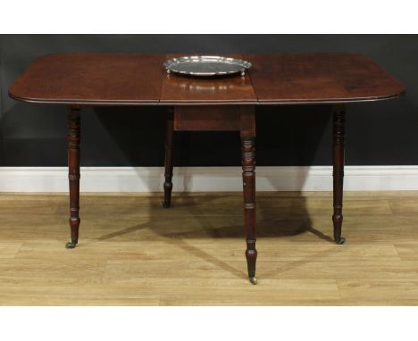 A Regency mahogany gateleg table, rounded rectangular top with channelled edge and fall leaves, ring-turned legs, brass caste