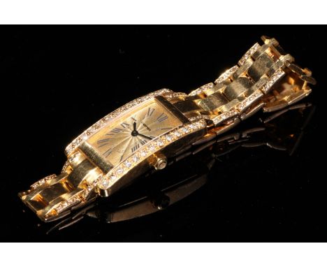 A lady's 18ct gold and diamond Cartier watch, champagne dial with Roman numerals, the case 35mm x 20mm, articulated bracelet,