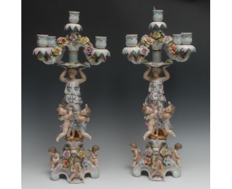 A pair of Continental figural five-light, four-branch candelabra, the columns with bare footed maidens and scantily clad cher