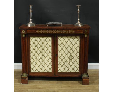 A Regency rosewood and brass marquetry side cabinet, rectangular top above a pair of panel doors, each set with pleated fabri