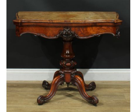 A Victorian walnut card table, hinged top enclosing a baize lined playing surface, shaped frieze carved and applied with scro