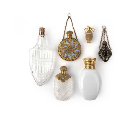 Five perfume bottles and a hardstone charm pendant, 19th century, comprising: a faceted glass bottle, capped in gold, length 