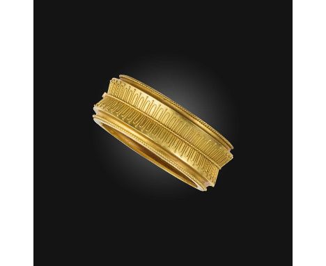 A Victorian gold bangle, late 19th century, of hinged construction, designed in the Archaeological Revival style, the front d