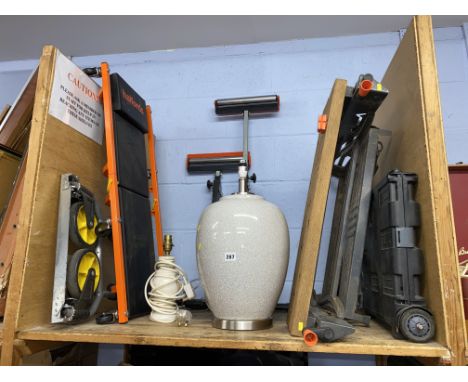Shelf of saw stands, trollies and two lamps