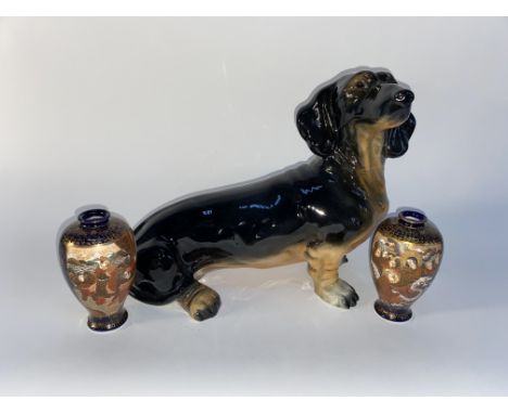 A ceramic Dachshund dog ornament, 40cm L and two miniature Satsuma ware vases