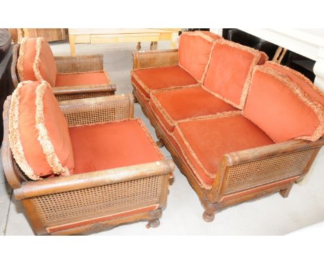 Four piece late Victorian walnut framed Bergere suite with carved detail comprising of three seat sofa and three matching arm