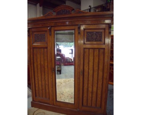 Maple & Co burr light oak combination three door wardrobe with raised carved cornice with part carved and panelled doors with