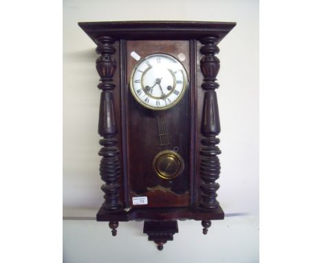 Late Victorian striking wall clock with white enamel dial and stained wood case 