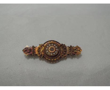 A Victorian 15ct gold bar brooch having a central diamond with seed pearl surround and moulded decoration&nbsp;CONDITION REPO