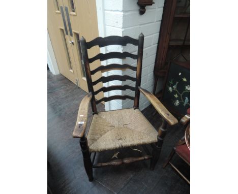 A 19th century elm vernacular armchair having ladder back with rush seat and turned frame