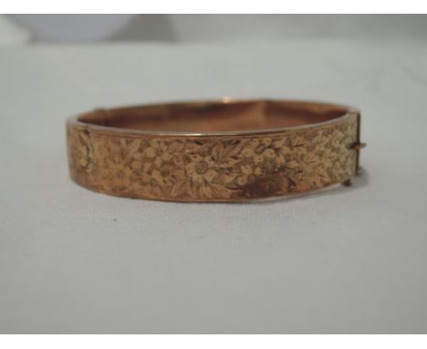 A 9ct rose gold hinged bangle having engraved foliate decorationCONDITION REPORT  Approx 13.6g