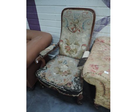 A Victorian oak frame armchair having floral tapestry upholstery on leaf head cabriole legs