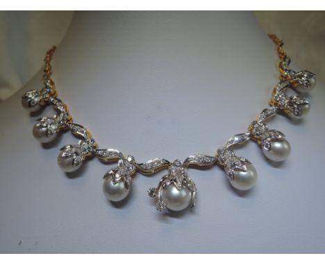 A south sea pearl and diamond necklace having nine pearls in diamond set mounts on a fixed fancy link yellow metal chain, no 