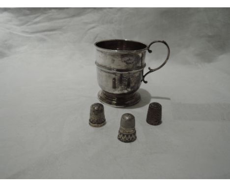 A small silver Christening mug of plain waisted form having loop handle and pedestal foot, Birmingham 1928, William Suckling 