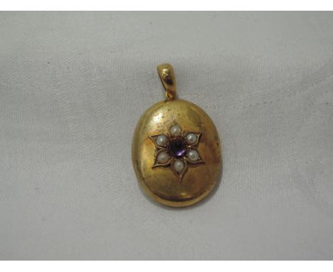 A yellow metal oval pendant having split pearl and amathyst cabouchon decoration to front and glass locket panel to reverse, 