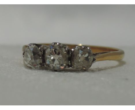 A lady's dress ring having a trilogy of old cut diamonds, total approx 0.6ct in a claw set mount on a yellow metal loop stamp