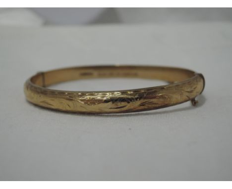 A 9ct gold hinged bangle having engraved scroll decorationCONDITION REPORT  Approx 8.7g