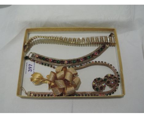 A small selection of vintage gold plated costume jewellery including an articulated bracelet by Dorsa, a ribbon style brooch 