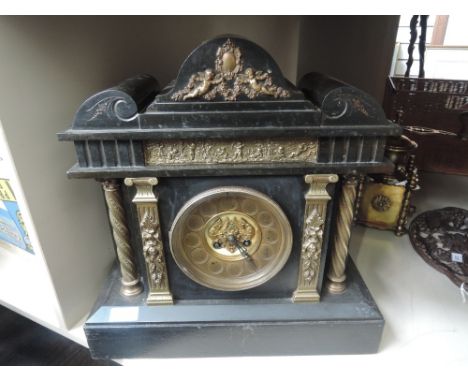 A late Victorian black marble mantel clock of architectural design having classical brass applique and columns and circular d