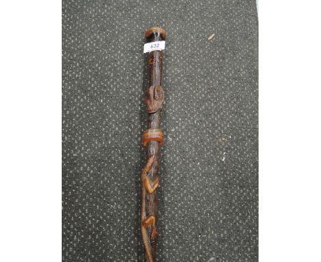 A vintage treen walking stick of Mexican mystic design