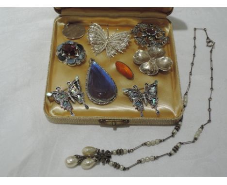 A small selection of HM silver and white metal jewellery including butterfly wing pendant, filligree and pau pau shell butter