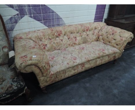 A Victorian sofa having button down floral upholstery and turned legs