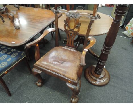 An early 20th Century mahogany corner armchair in the Chippendale style having lattice scroll back , drop in leather seat and