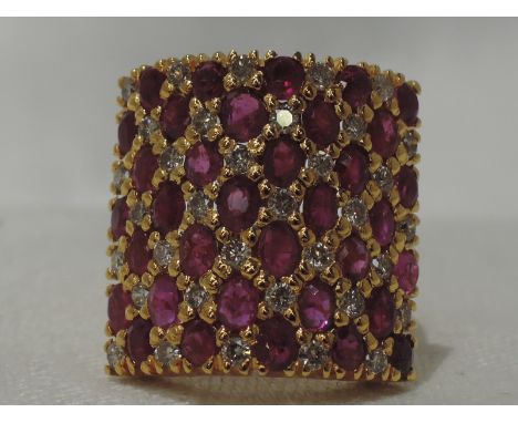 A lady's dress ring having a ruby and diamond set panel on a yellow metal loop, no marks previously tested as 18ct gold, with