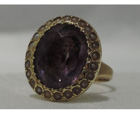 A lady's dress ring having an oval amethyst with seed pearl surround attached to a 9ct gold signet ring,  size Q