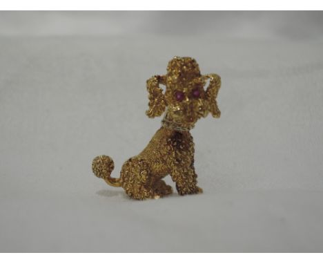 A yellow metal brooch stamped 750 modelled as a seated poodle with ruby set eyesCONDITION REPORT  Approx 10g