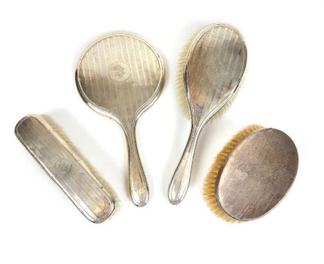 A silver dressing table set, comprising; two brushes and a mirror, and a silver gentleman's hairbrush.Birmingham 1910 (4)