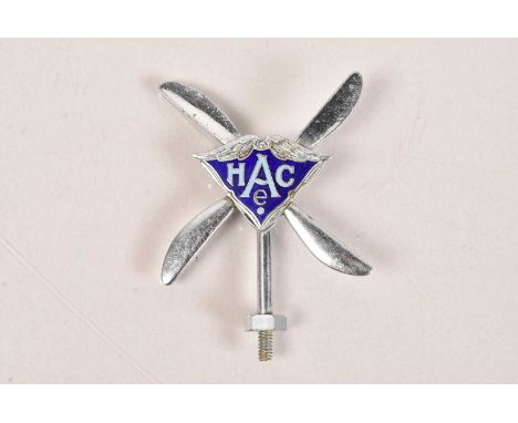 A Vintage HACE Car Badge by Thomas Fattorini, with blue enamel decoration, infront of a four blade propeller, 6.5cm wide