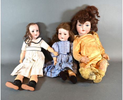 A Heubach Koppelsdorf German Bisque Headed Doll No. 3021 with composition body together with two other similar German bisque 