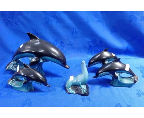 FOUR POOLE POTTERY DOLPHINS with a Poole Pottery seal (chipped)