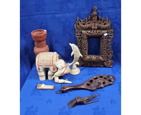 AN INDONSIAN CARVED WOODEN FRAME together with wooden elephant puppet, an incised bone, a plastic 'scrimshaw' and other items